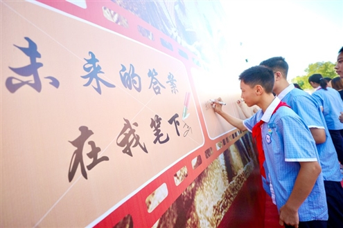 济南育英中学同学们在签名墙下写下名字展望未来